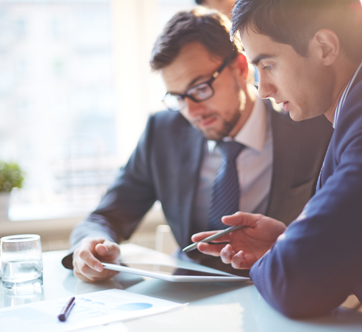 Man showing ipad with information to another man