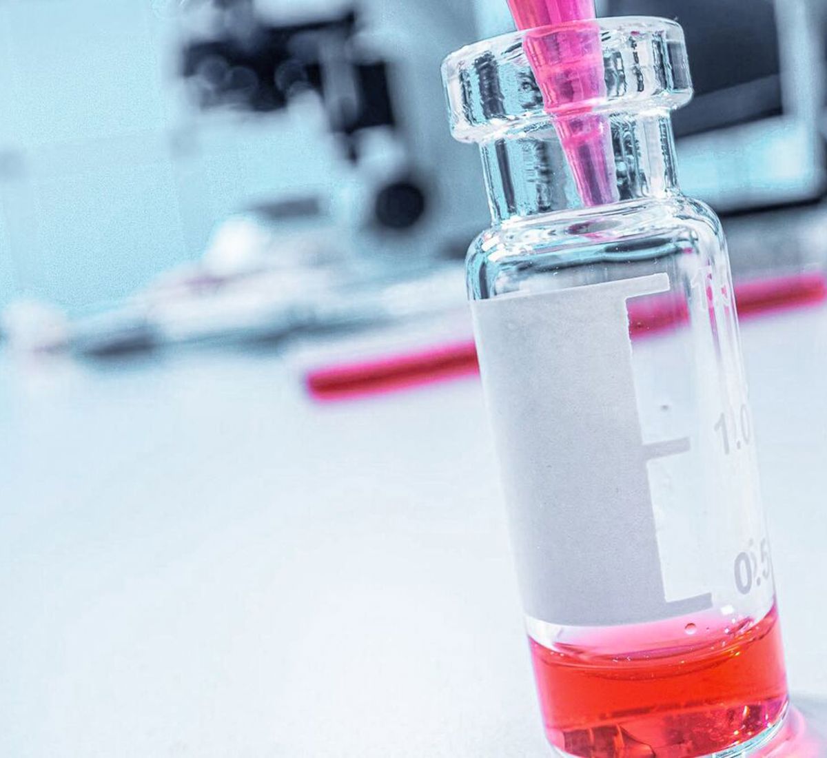 Vial of pink liquid being filled up by pipette